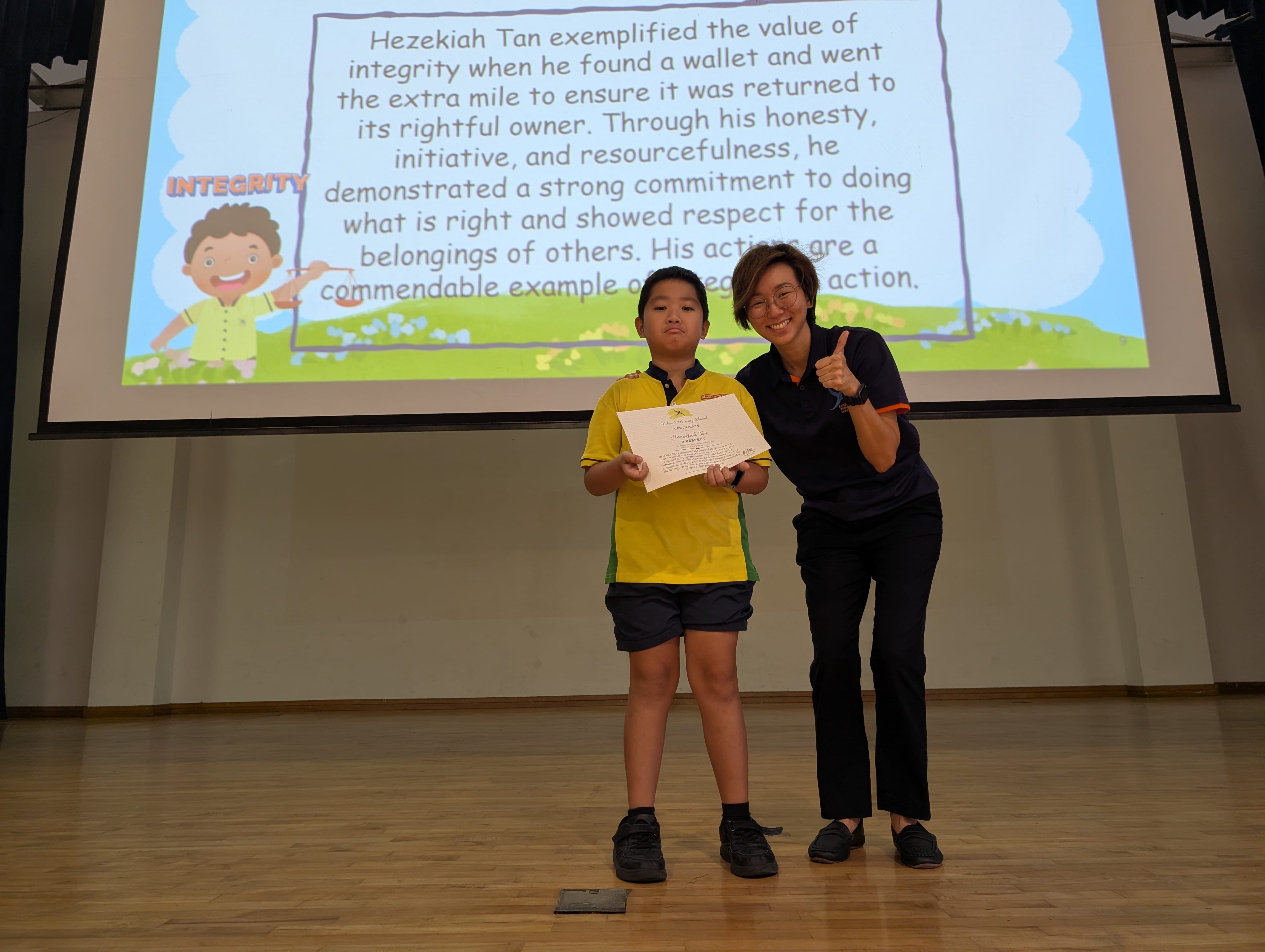 A boy receiving a certificate on the stage.